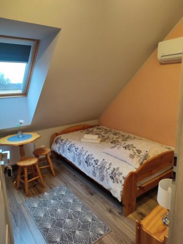 a small bedroom with a bed and a table at Willa Orle Gniazdo in Biały Kościół