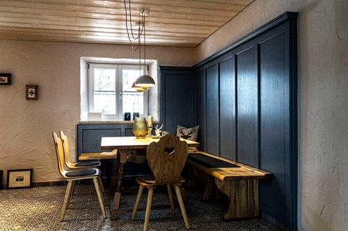 uma sala de jantar com uma mesa de madeira e cadeiras em Säntisblick em Oberstaufen
