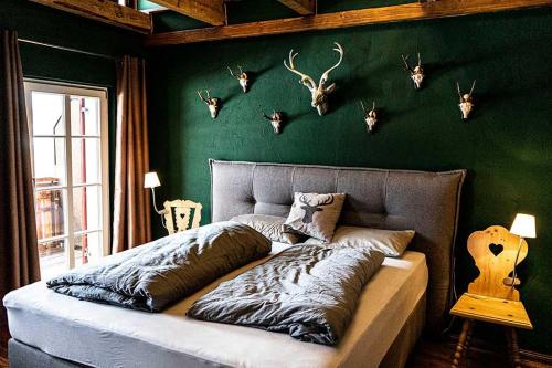 1 dormitorio con 1 cama con cabezas de ciervo en la pared en Säntisblick, en Oberstaufen