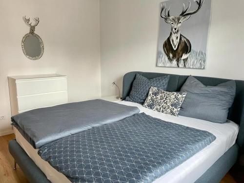 a bed in a bedroom with a deer picture on the wall at Allgäu-Idyll in Weiler-Simmerberg