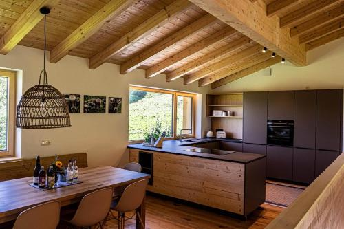 cocina con mesa de madera y techo de madera en Lohansler Hütte, en Oberstaufen