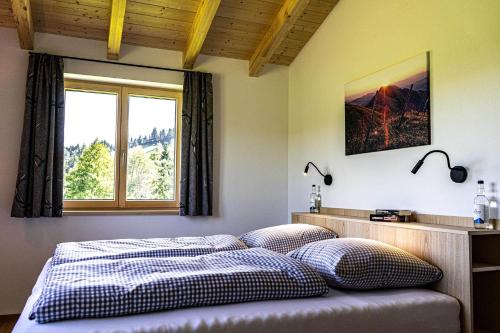 a bedroom with a bed with two pillows and a window at Lohansler Hütte in Oberstaufen