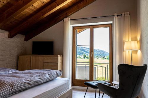 a bedroom with a bed and a large window at Himmelseck in Oberstaufen