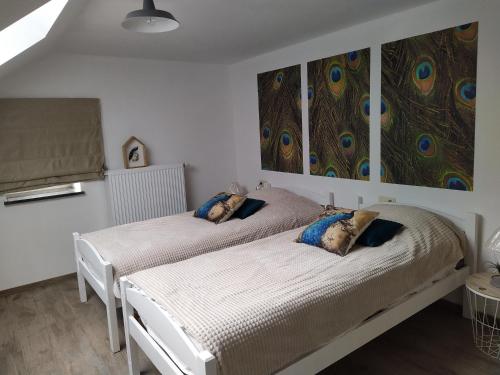 2 camas en un dormitorio con una pintura en la pared en Gîte Le Framboisier V de la distillerie Bio Spirit Belgium en Neufchâteau