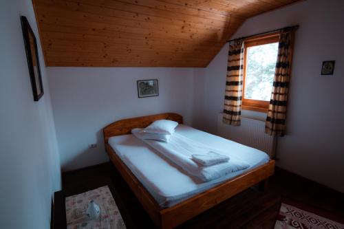 a bedroom with a bed in a room with a window at Cabana Lăcrămioara in Dejani