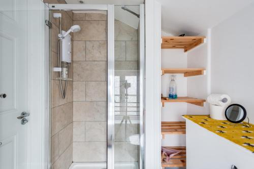 a shower with a glass door in a bathroom at The Mews - 1BR Studio in Jericho near City Centre in Oxford