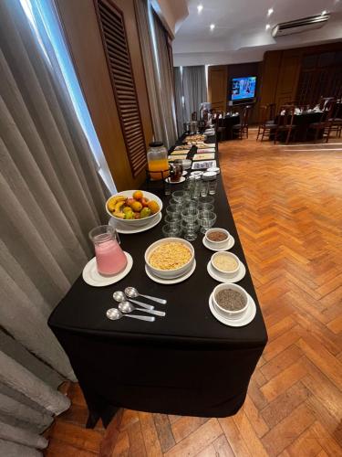 a long black table with food and drinks on it at Hotel Catalinas Tucuman in San Miguel de Tucumán