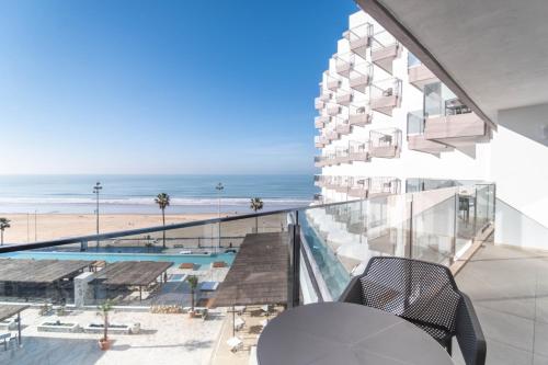 a view of the beach from the balcony of a building at Cádiz Bahía by QHotels in Cádiz
