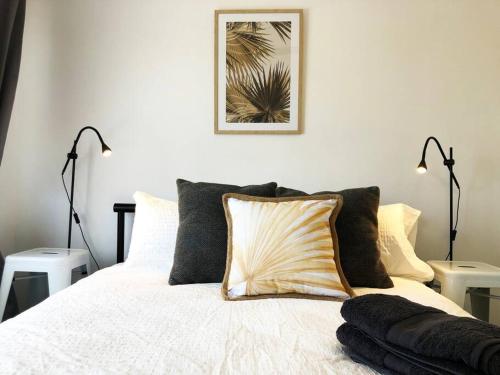 1 dormitorio con 1 cama blanca y 2 lámparas en Few Steps Into Town - Corner House en Geraldton