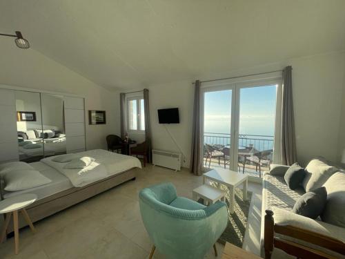 ein Schlafzimmer mit einem Bett und ein Wohnzimmer mit Aussicht in der Unterkunft Almond Apartments in Sveti Stefan
