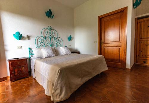 una camera da letto con un letto e una porta di legno di Turismo Rurale CUDACCIOLU a Arzachena