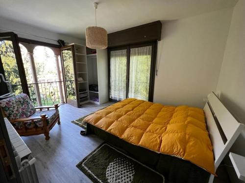 a bedroom with a large bed with a yellow blanket at Appartamento in Villa Storica in Oleggio Castello