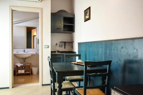 una cucina con tavolo nero, sedie e lavandino di Hotel La Plage a Cattolica