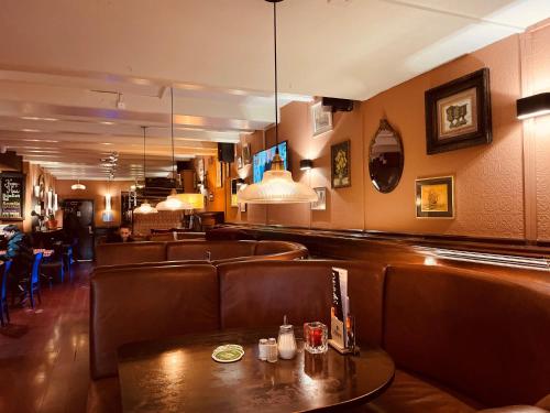 un bar con sedili in pelle marrone e un tavolo di Hotel Old Quarter ad Amsterdam