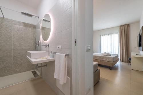 a bathroom with a shower and a sink and a mirror at Palazzo Michelangelo in Villasimius