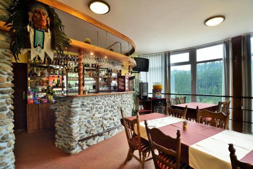 ZvoleにあるHotelový resort Šiklandのテーブルと椅子のあるレストラン、石造りのバー
