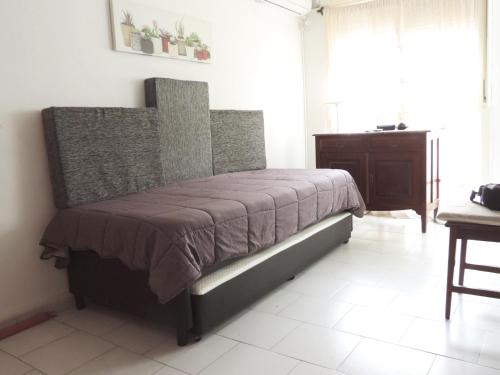 Un dormitorio con una cama con una manta marrón. en Alvear Bis en Rosario