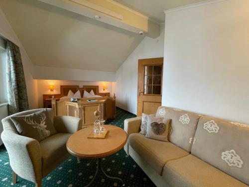 a living room with a couch and a table at Wohlfühlhotel Berwanger Hof in Obermaiselstein