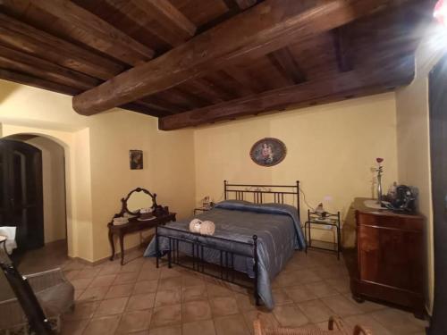 a bedroom with a bed and a wooden ceiling at La Casa del Nonno in Porano
