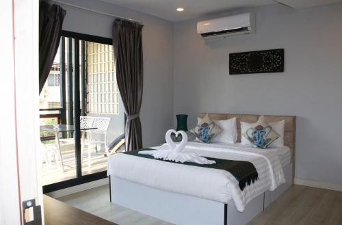 um quarto com uma cama branca e uma varanda em Ostro Hotel em Phnom Penh