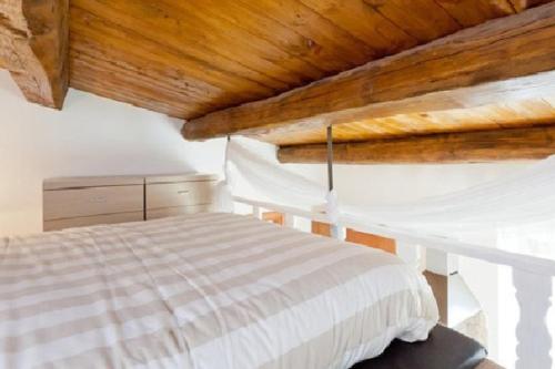 ローマにあるBrancaleone86 - The Loftの木製の天井のベッドルーム1室(白いベッド1台付)