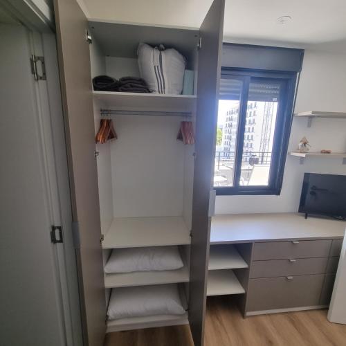 a closet with white shelves and a window at EXCLUSIVO PENTHOUSE EN CORDON SOHO CON DISNEY PLUS y PARKING INCLUIDOS in Montevideo