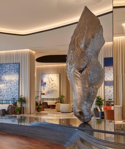 a lobby with a statue of a head on the floor at Grand Hyatt Kuwait in Kuwait