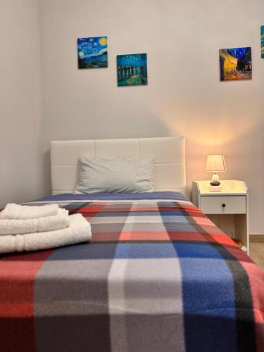 um quarto com uma cama com um cobertor listrado em Holidays Apartment em Cagliari