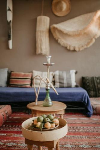 a living room with a table with a bowl of fruit at Riad Alnadine in Marrakech