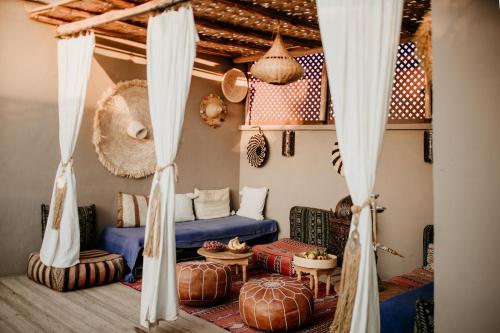 een woonkamer met een blauwe bank en gordijnen bij Riad Alnadine in Marrakesh