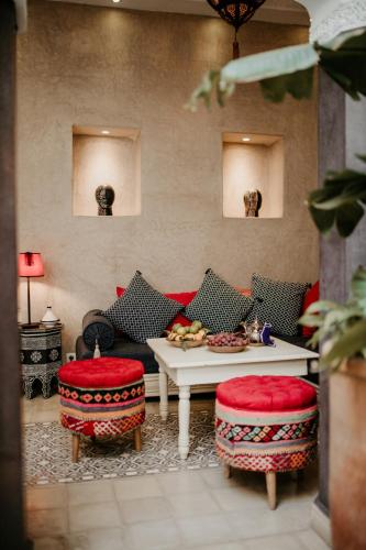 a living room with a couch and a table and chairs at Riad Alnadine in Marrakech