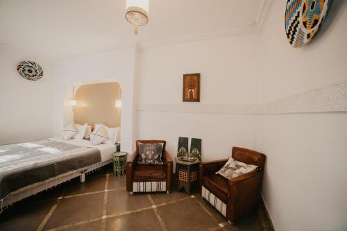 a bedroom with a bed and a chair at Riad Alnadine in Marrakech