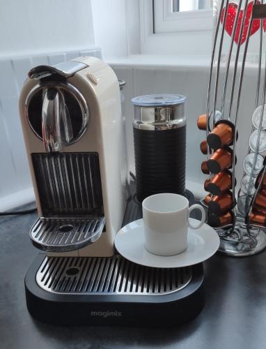 a coffee maker with a cup on a counter at The Stables in Tregaron