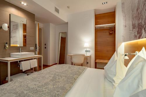 Habitación de hotel con cama y lavabo en Hotel Párraga Siete, en Granada