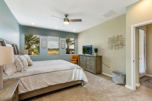 ein Schlafzimmer mit einem Bett und einem TV in der Unterkunft Lake Breeze at Ellis Exclusive Villas in Kissimmee