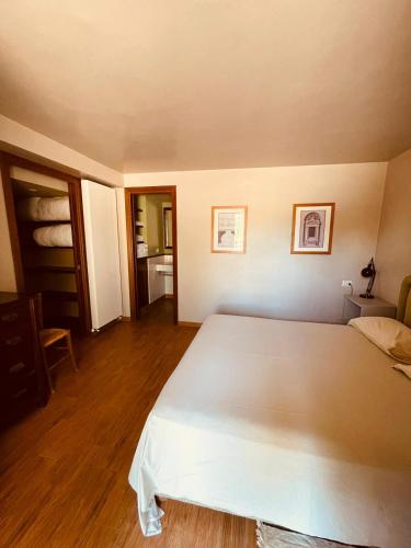 a bedroom with a large white bed and wooden floors at Agriturismo Casale Montebello in Monteleone di Spoleto
