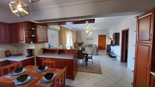una cucina e un soggiorno con tavolo e sedie di Makarios Apartment Near Athens Aiport a Spata