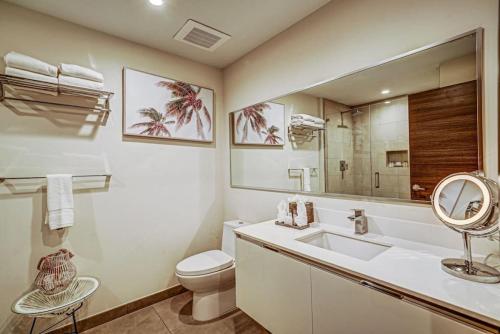 a bathroom with a sink and a toilet and a mirror at Beachside Luxury KING Suite in 4 Star Resort with Rooftop Bar and Pool in Hollywood