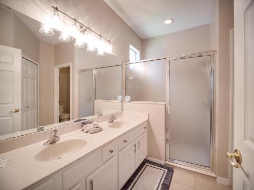 a bathroom with two sinks and a shower at Casa Amore at Ellis Exclusive Villas in Davenport