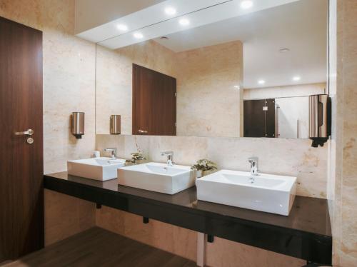 a bathroom with two sinks and a mirror at Mercure Cieszyn in Cieszyn