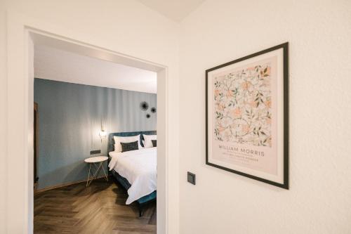 a bedroom with a bed and a picture on the wall at Moderne 3 Zi-FeWo "Vintage Style" 70 qm Nähe Freiburg in Simonswald