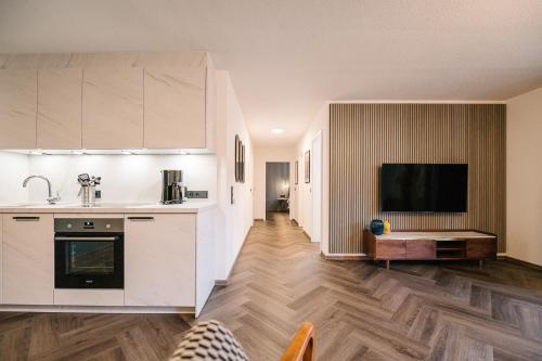 een keuken met witte kasten en een houten vloer bij Moderne 3 Zi-FeWo "Vintage Style" 70 qm Nähe Freiburg in Simonswald