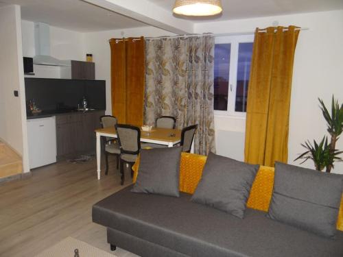 Cosy Loft - Appartement de charme في مارساناي-لا-كوت: غرفة معيشة مع أريكة وطاولة