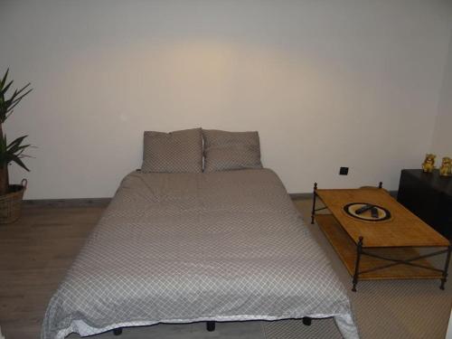 a large bed in a room with a table at Cosy Loft - Appartement de charme in Marsannay-la-Côte