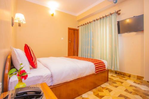 Un dormitorio con una cama y un escritorio con un Sidx de mesa en Hotel Liberty Pokhara, en Pokhara
