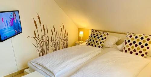 a bedroom with a bed and a tv on the wall at Ferienhäuser mit Seeblick direkt am Plauer See in Plau am See