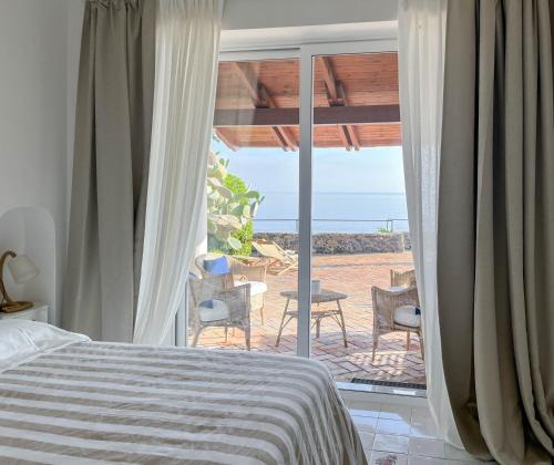 1 dormitorio con cama y vistas al océano en Nelinda Waterfront Accommodation, en Isquia