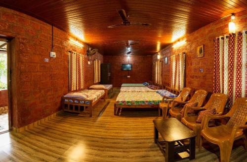 una camera con due letti e sedie in un edificio di jasmine land homestay a Udupi