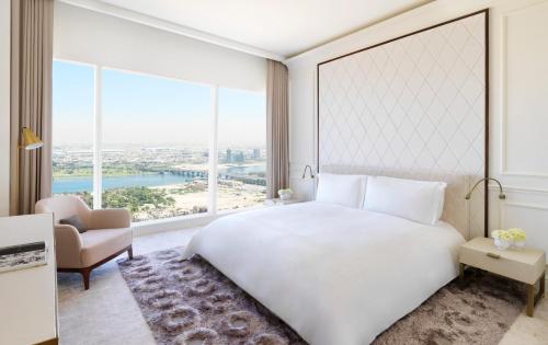 a bedroom with a large white bed and a large window at Sofitel Dubai The Obelisk in Dubai