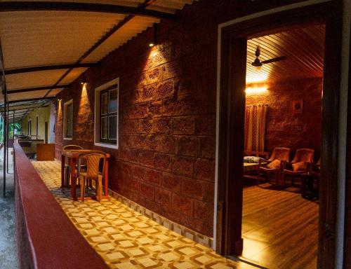 a room with a brick wall and a table and chairs at jasmine land homestay in Udupi